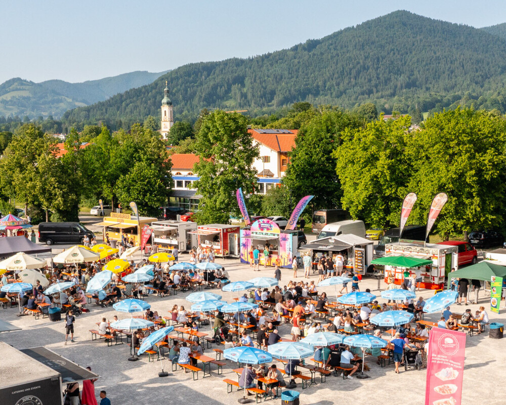 Überblick über das Streetfood-Festival in Lenggries, im Hintergrund das Dorf mit der Kirche.