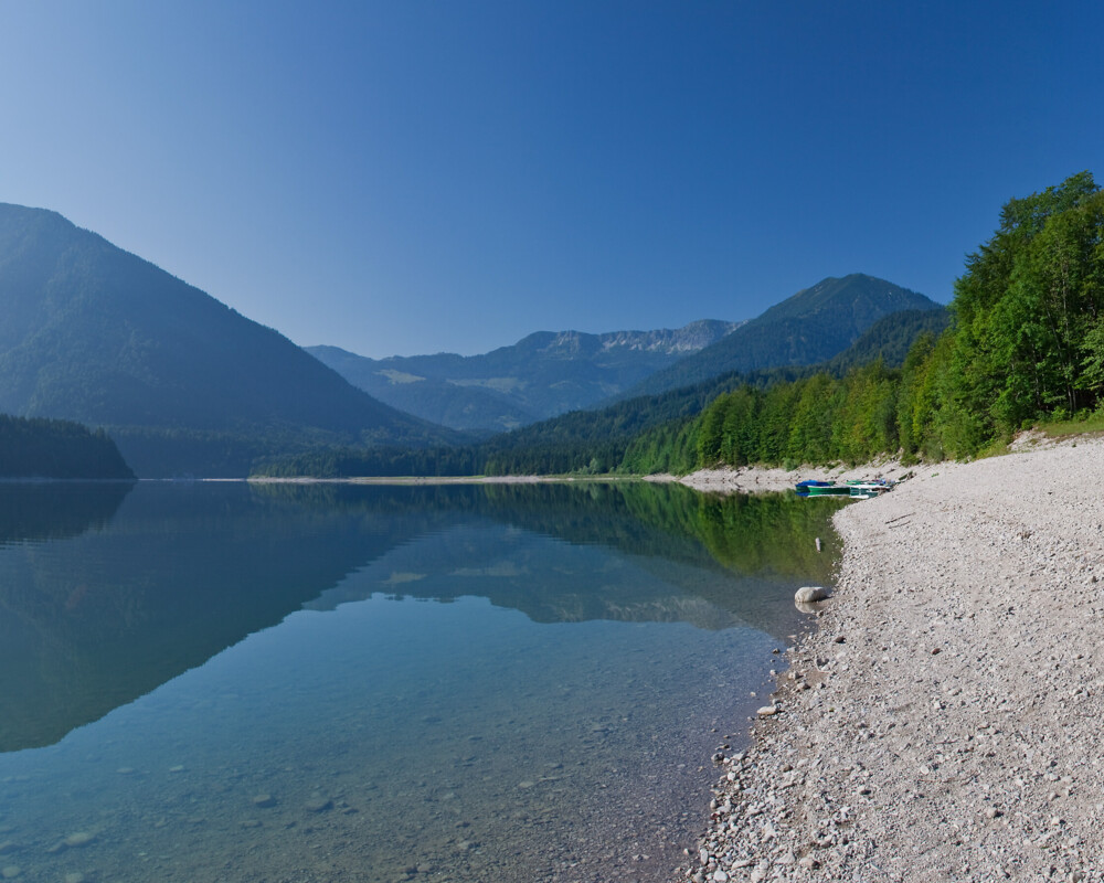 Ufer am Sylvensteinsee mit Bergen im Hintergrund