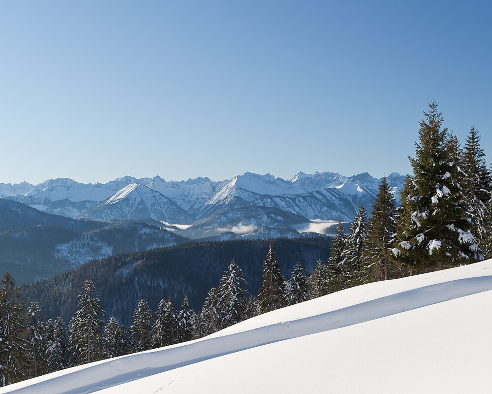 Ein Verschneiter Berghang mit Blick ins Karwendel