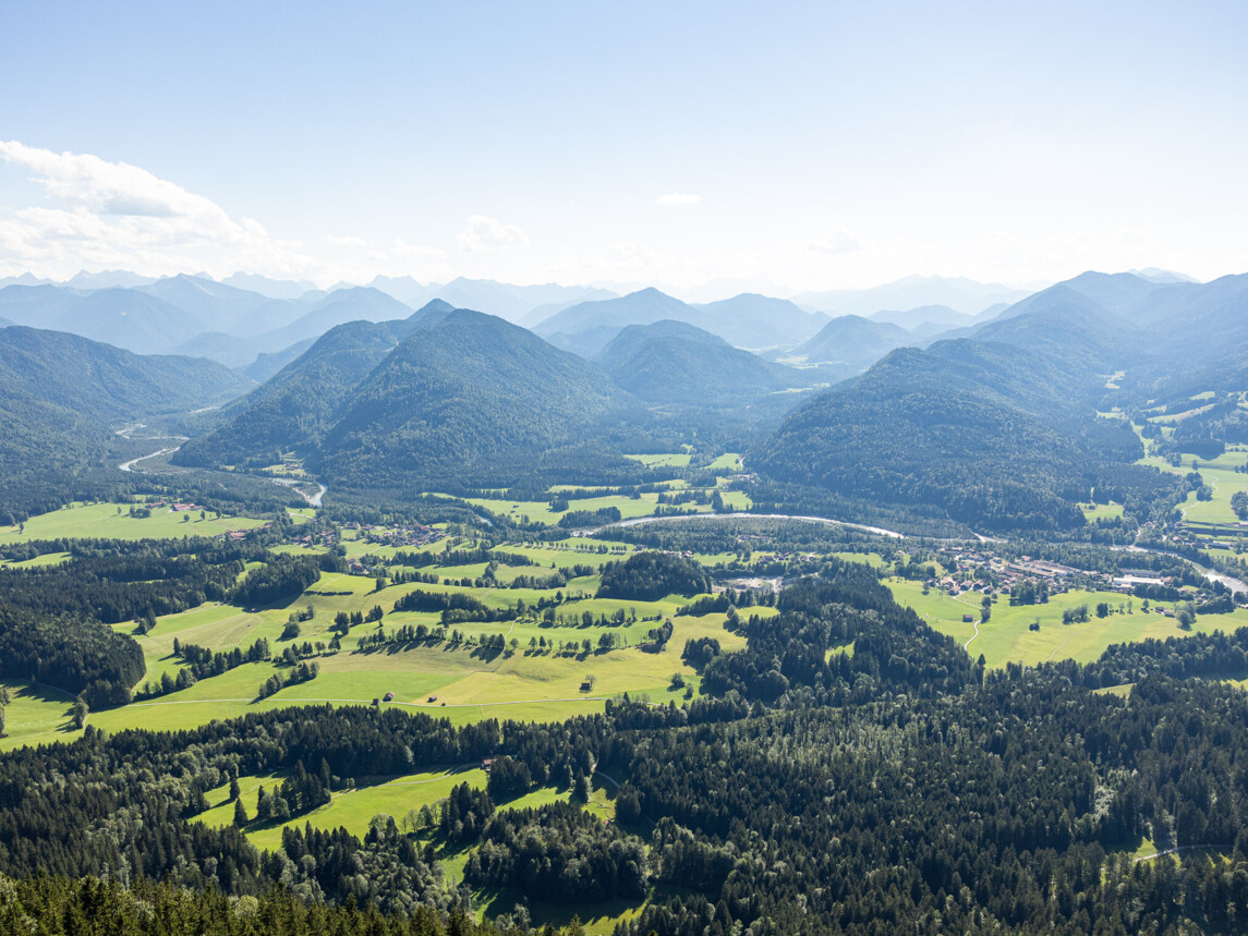 Man schaut von einem Berg in das Tal und auf die anderen Berge