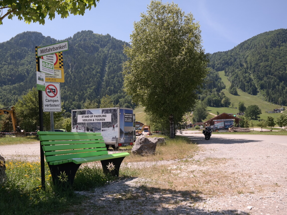Zu sehen ist eine grüne Bank vor dem Brauneck 