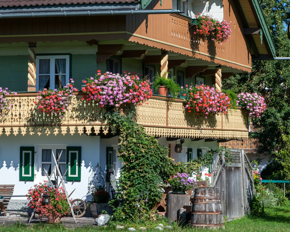 Ein Bauernhaus mit Geranien auf dem Balkon