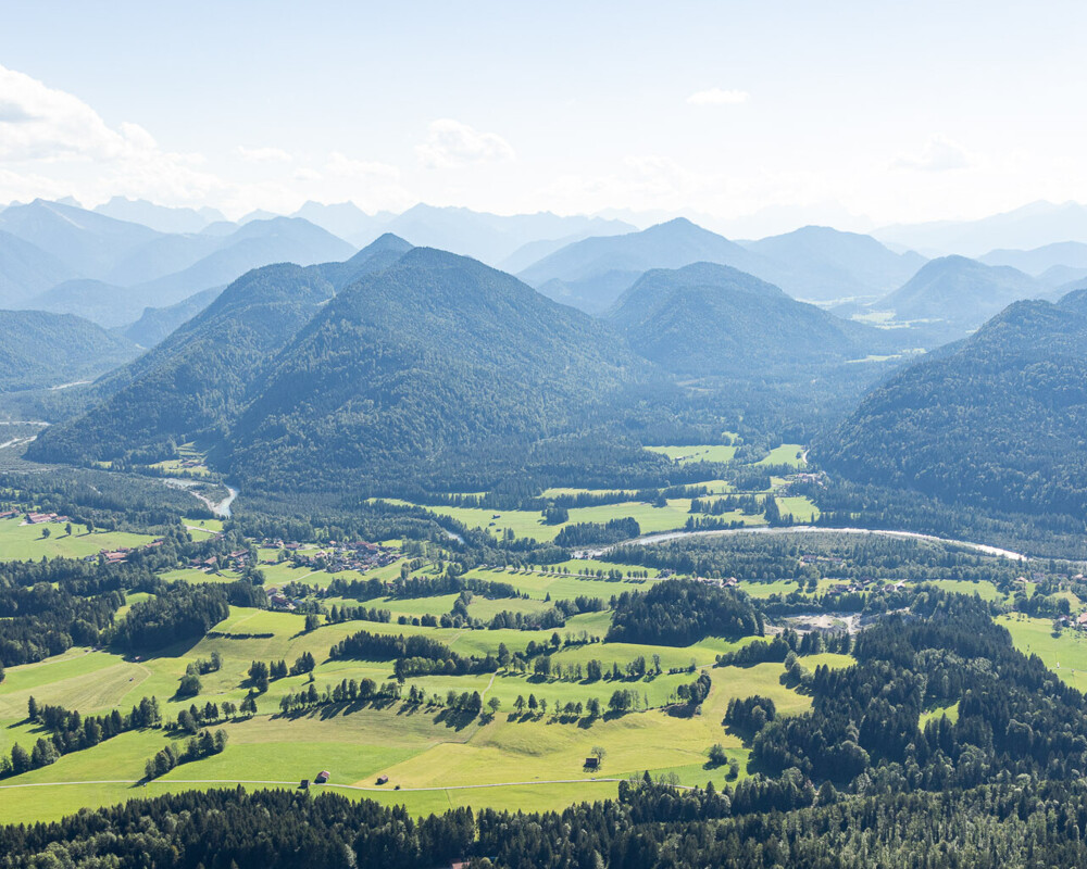 Man schaut von einem Berg in das Tal und auf die anderen Berge