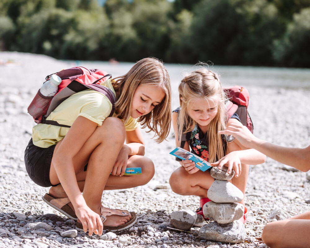 Kinder bauen Steinmännchen an der Isar