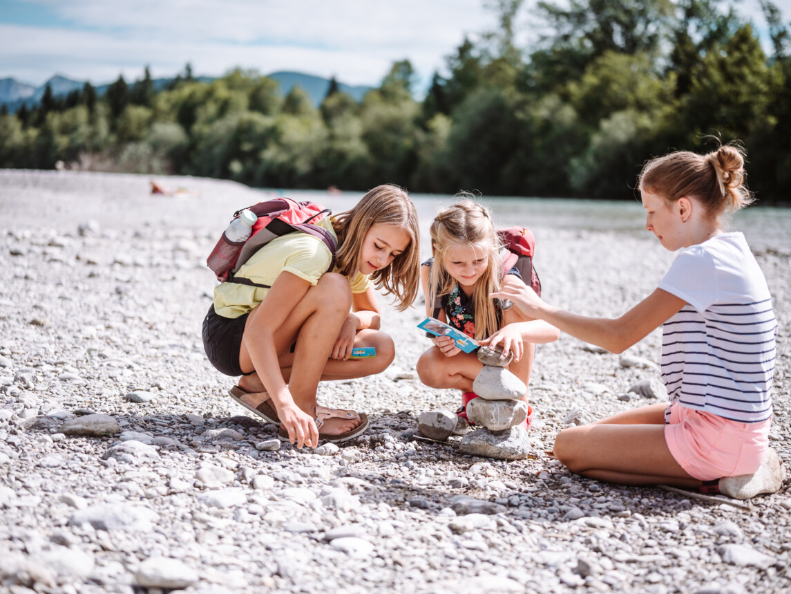 Kinder bauen Steinmännchen an der Isar