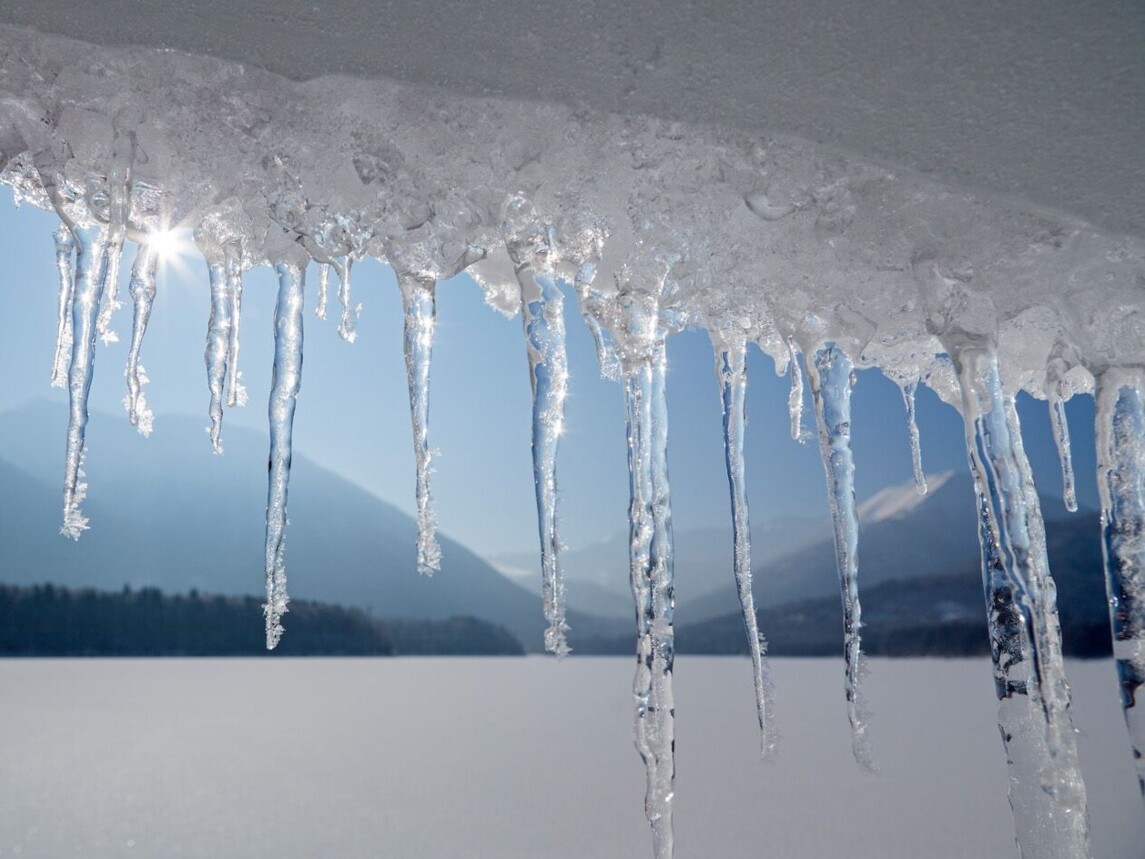 Eiszapfen mit gefrorenem Sylvensteinsee im Hintergrund