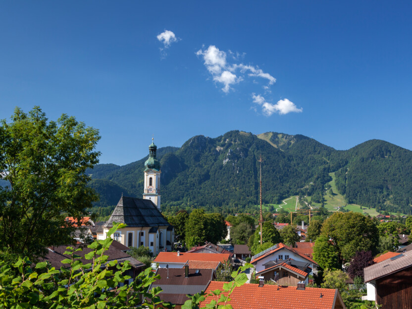 Tourismus Lenggries, Foto: C. Bäck, Lenggrieser Ortskern Lenggrieser Ortskern mit Kirche und Brauneck im Hintergrund.