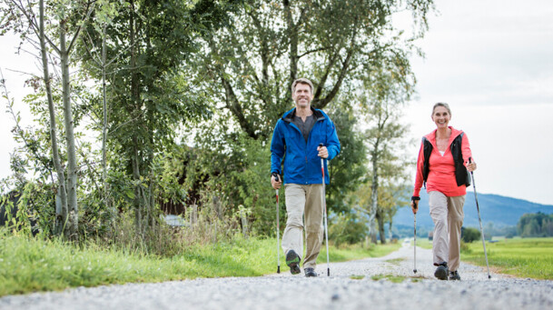 Ein älteres Paar beim Nordic Walking