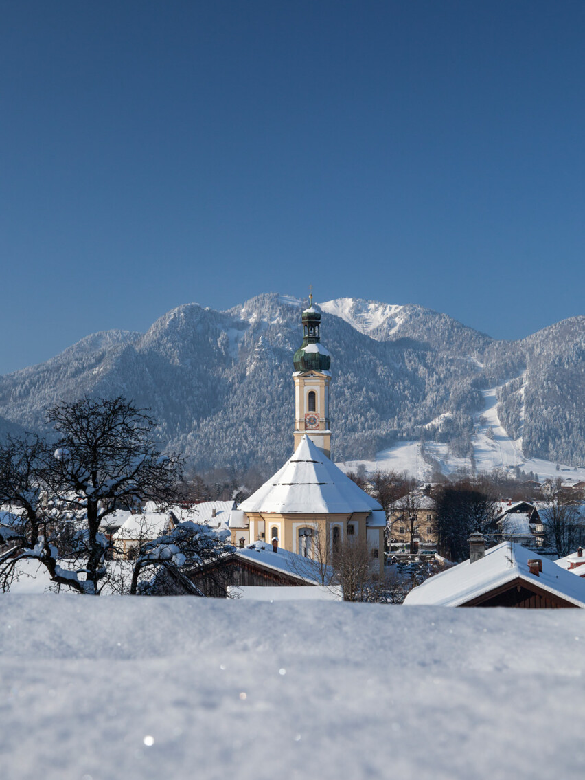 Lenggrieser Ortsmitte mit Brauneck im Hintergrund im Winter