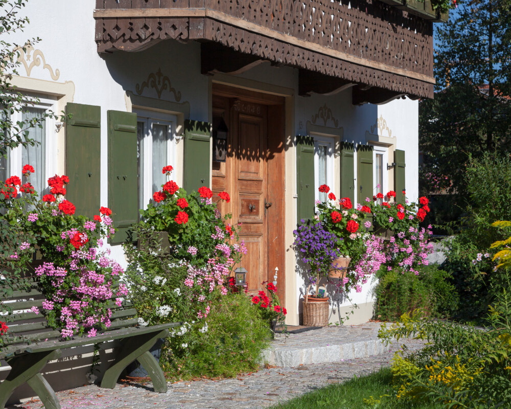 Blumen und Bank beim Eingang ins Bauernhaus