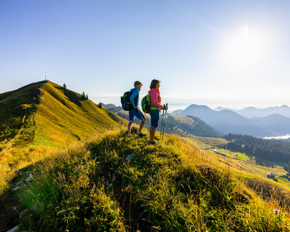 Ein Paar am Seekarkreuz schaut ins Tal beim Sonnenaufgang