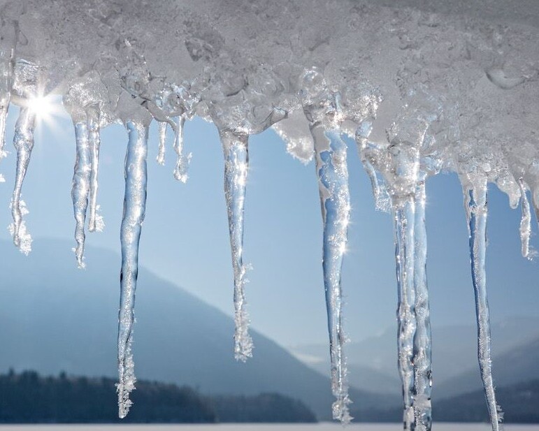 Eiszapfen mit gefrorenem Sylvensteinsee im Hintergrund
