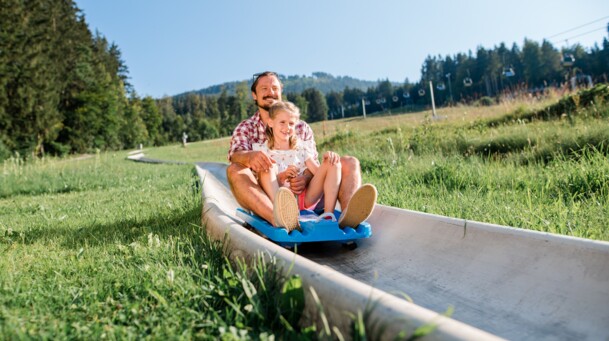 Vater und Tochter auf der Sommerrodelbahn am Blomberg