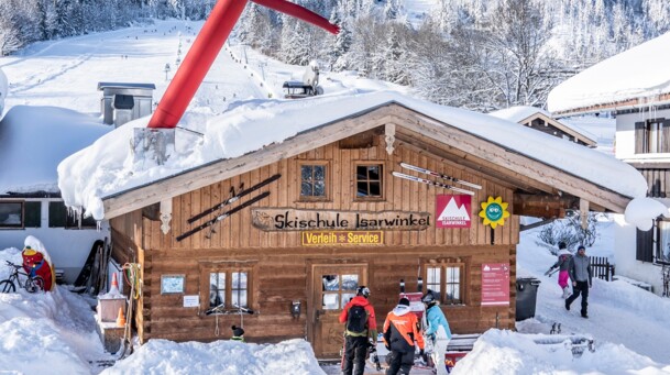 Gebäude der Skischule Isarwinkel mit Blick auf das Brauneck