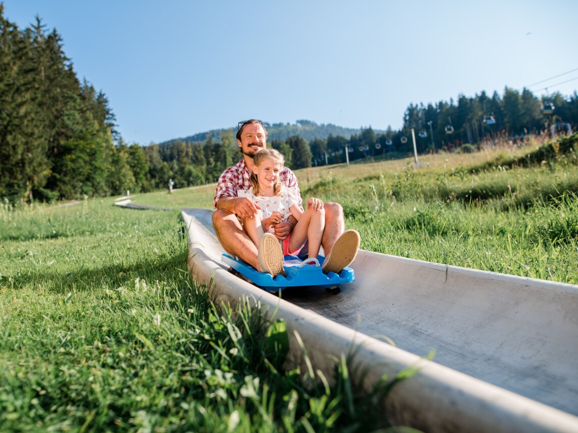 Vater und Tochter auf der Sommerrodelbahn am Blomberg