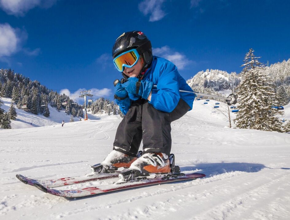 Kind beim Skifahren in Abfahrtsposition