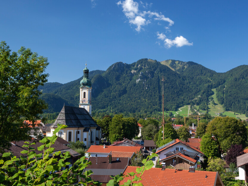 Lenggrieser Ortskern mit Kirche und Brauneck im Hintergrund.