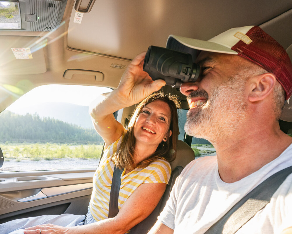 Unterwegs im Auto erkunden zwei Urlauber die beeindruckende Landschaft von Lenggries – immer auf der Suche nach neuen Ausblicken und Abenteuern.