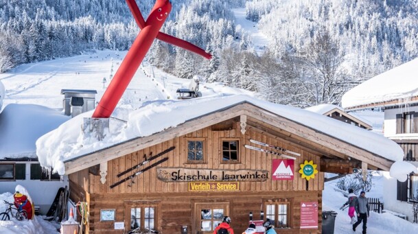 Gebäude der Skischule Isarwinkel mit Blick auf das Brauneck