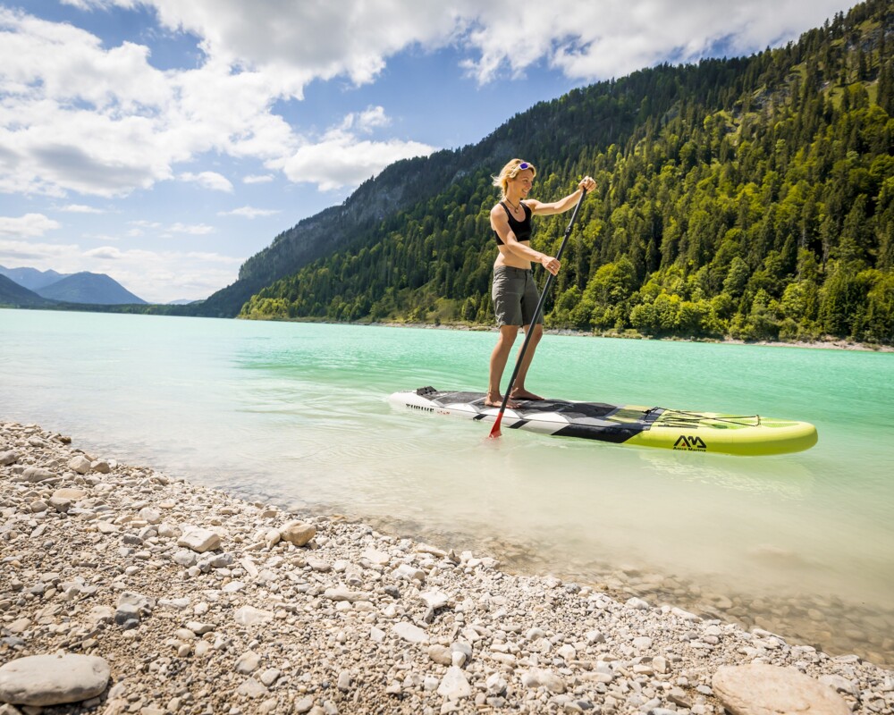 Tourismus Lenggries, Ch. Bäck, SUP am Sylvensteinsee Frau auf einem Stand up Paddle am Sylvensteinsee