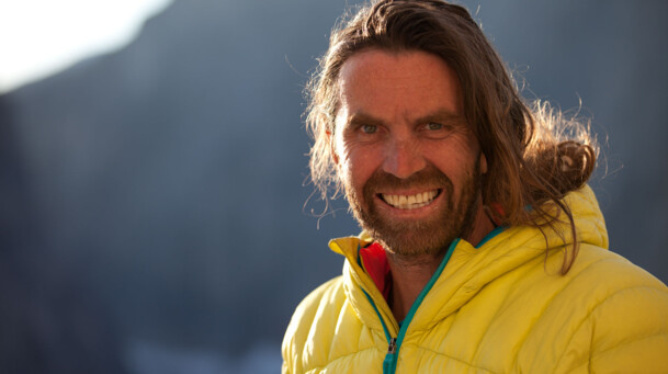 Portraitaufnahme von Thomas Huber, der mit einer gelben Jacke gekleidet ist. 