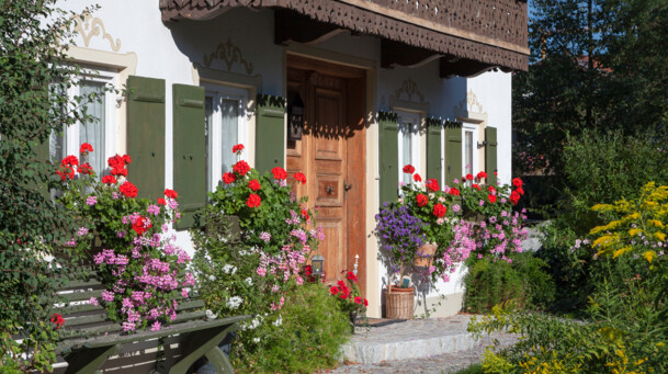 Blumen und Bank beim Eingang ins Bauernhaus