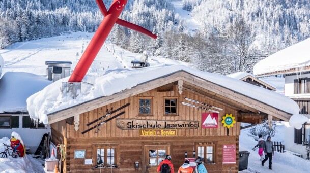 Gebäude der Skischule Isarwinkel mit Blick auf das Brauneck