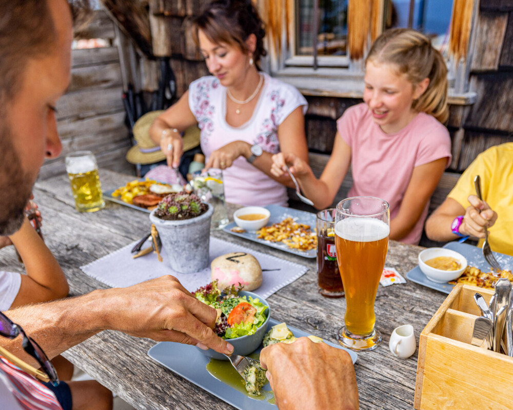 Familie beim Essen auf der Quenger-Alm bei Lenggries