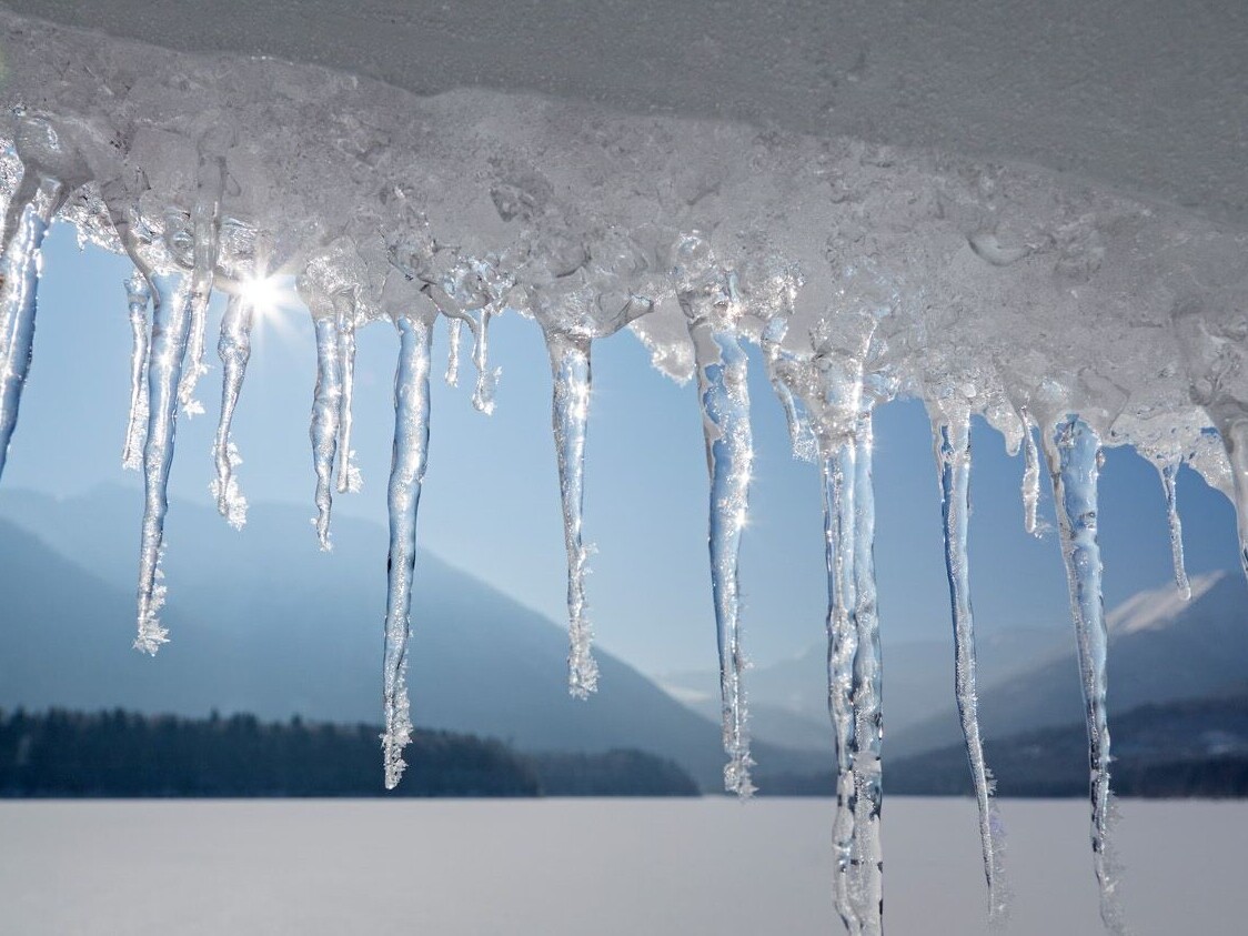 Eiszapfen mit gefrorenem Sylvensteinsee im Hintergrund