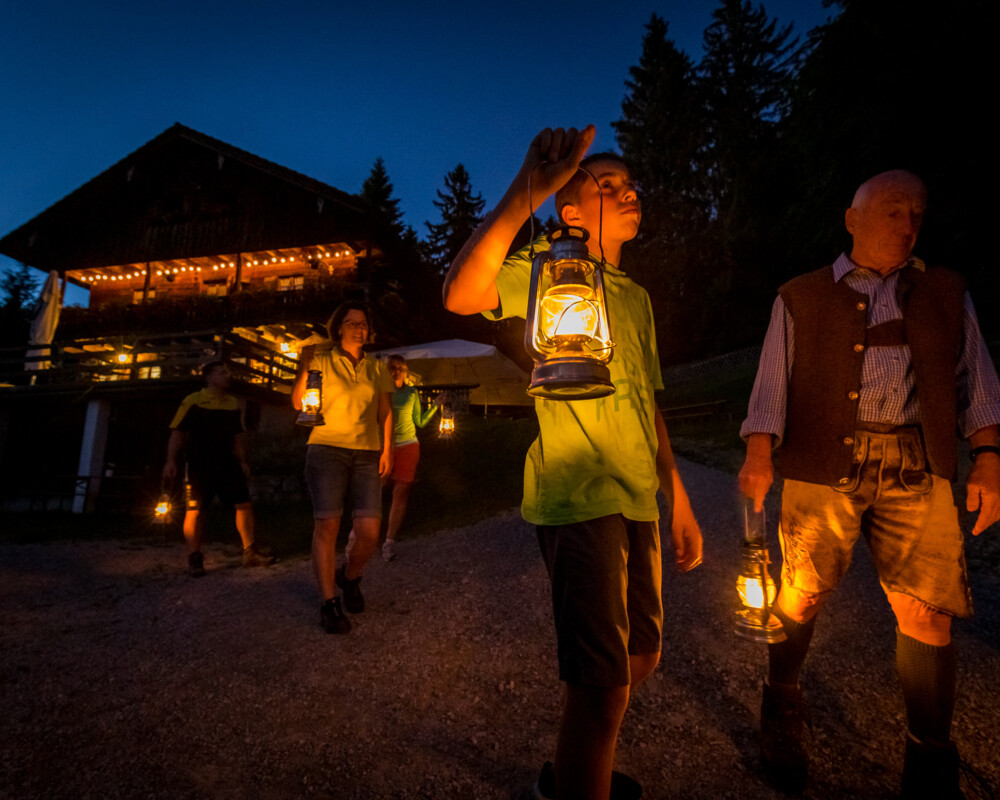 Familie bei einer Laternenwanderung vor der Denkalm