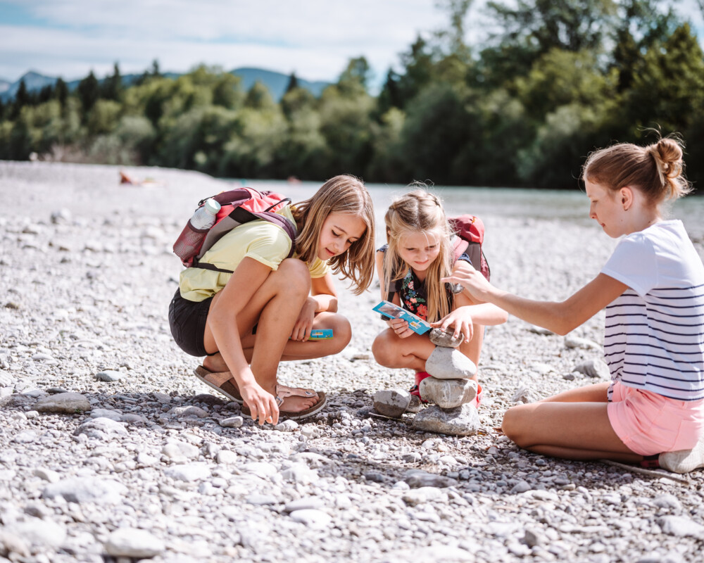Kinder bauen Steinmännchen an der Isar