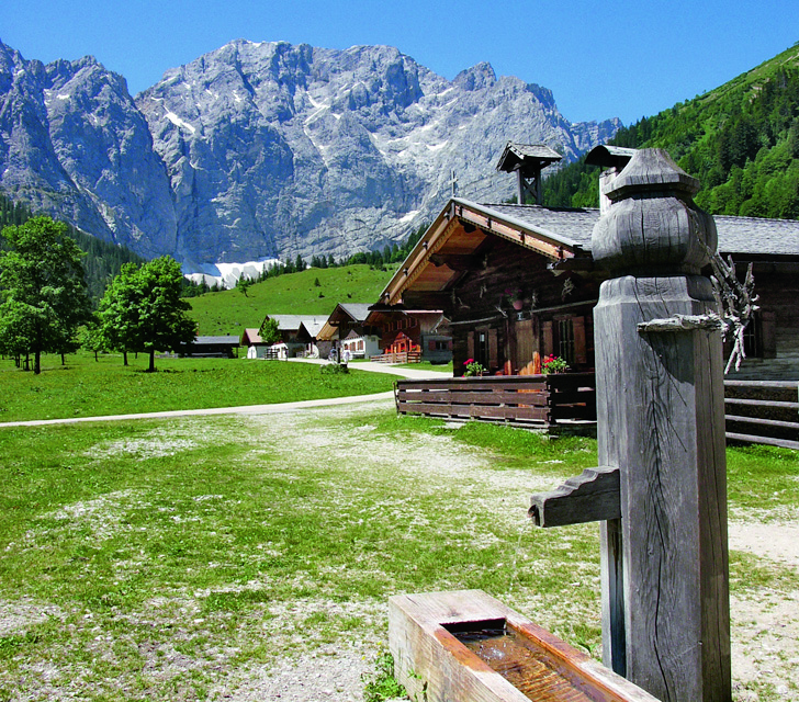 Ein Brunnen und Almen unterhalb der Karwendel-Gipfel