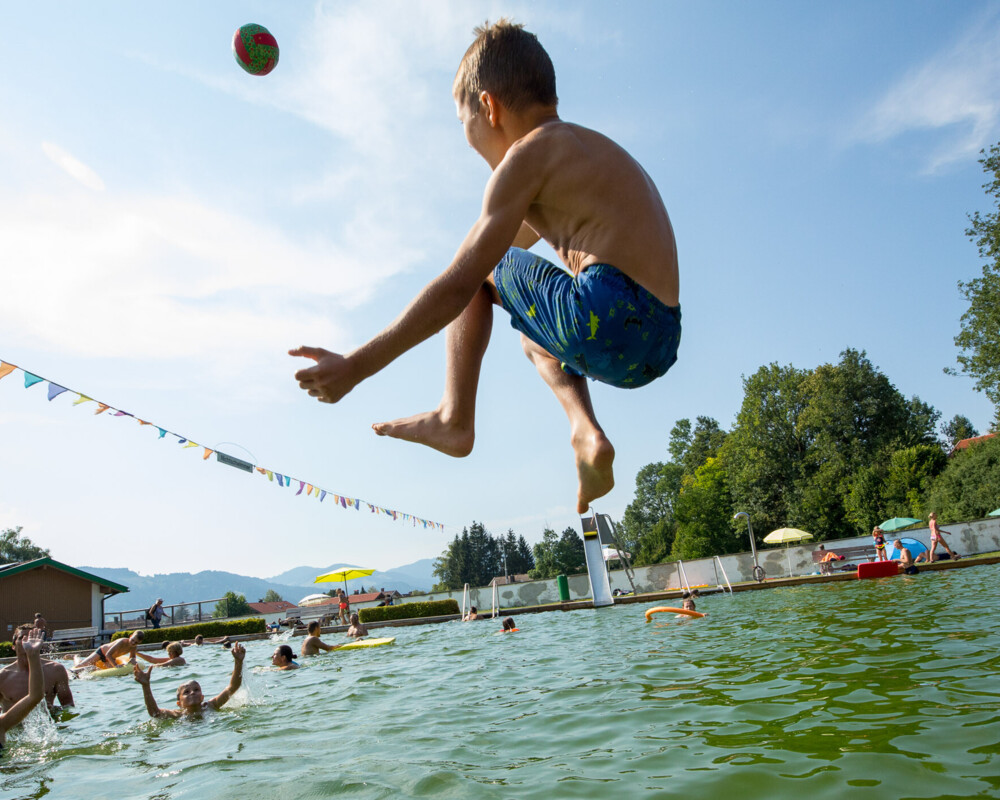 Junge springt in das Becken des Lenggrieser Freibades