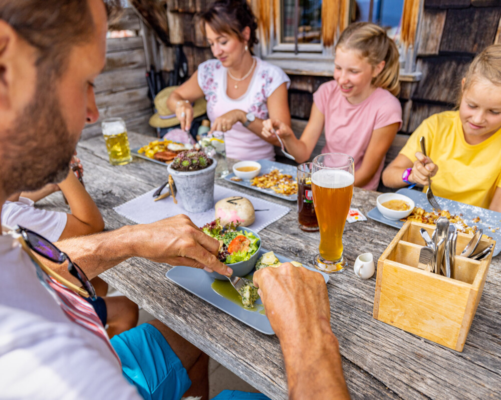 Familie beim Essen auf der Quenger-Alm bei Lenggries