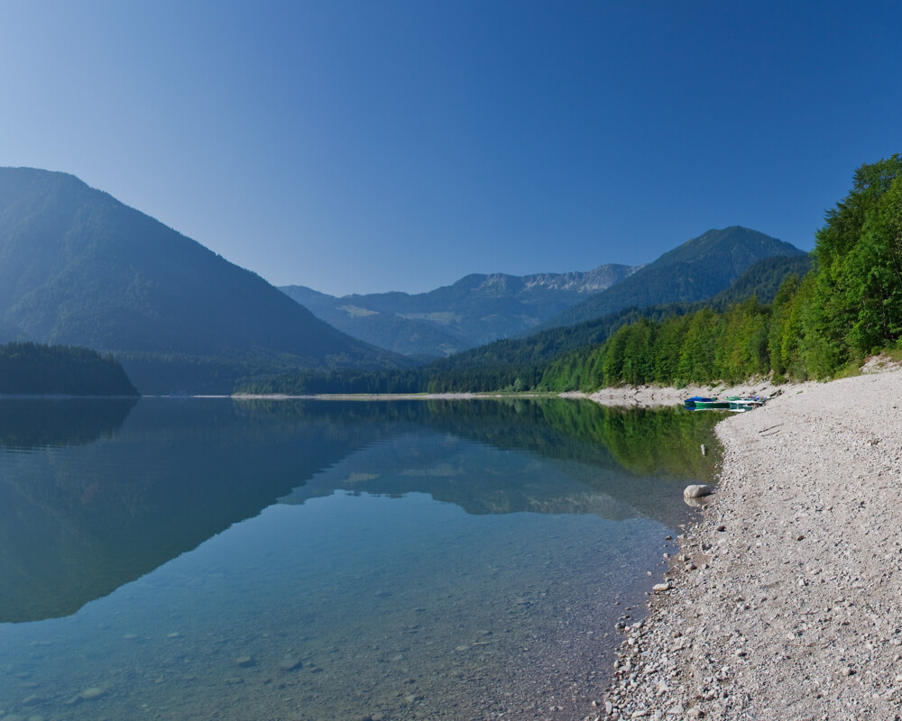 Ufer am Sylvensteinsee mit Bergen im Hintergrund