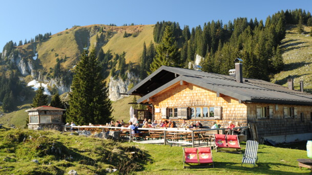 Tölzer Hütte am Brauneck mit Liegewiese im Vordergrund 