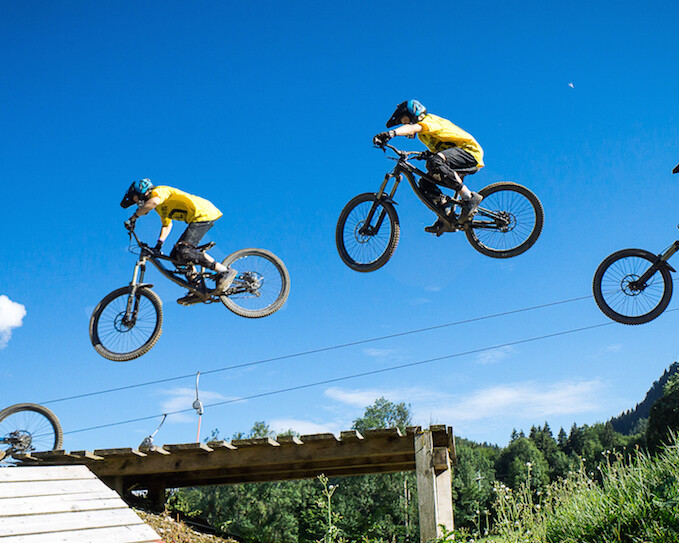 Ein Junge springt mit Bike im Bogen im Bikepark Lenggries