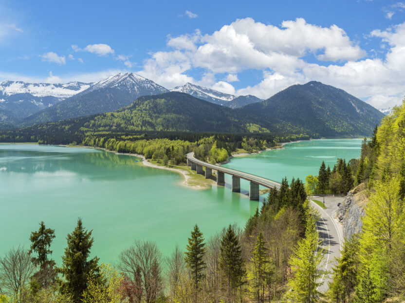 Sylvensteinsee mit Brücke und verschneitem Karwendelgebirge im Hintergrund